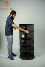 a man rotating dark grey rotatable shoe storage contains decorative plants with a white background and logo barqasha